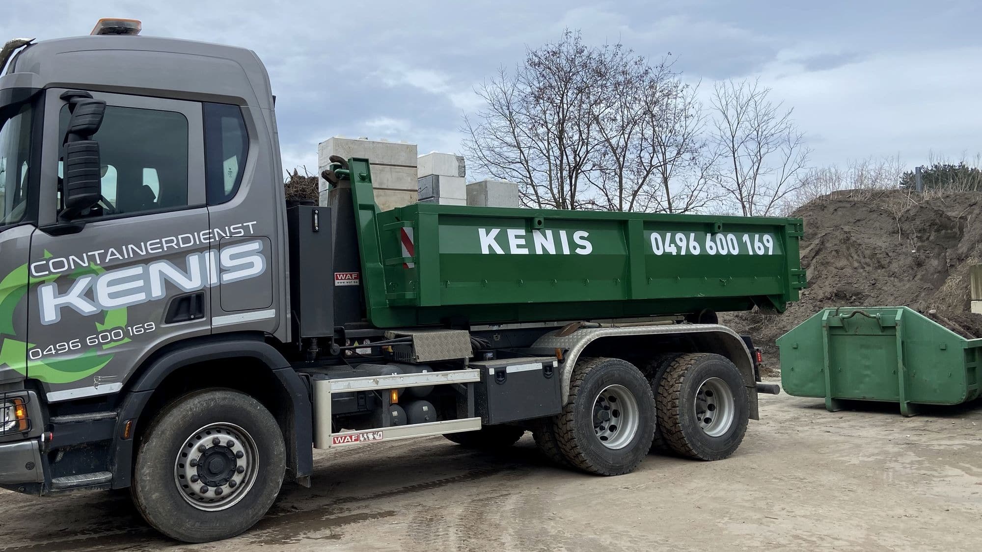 Vrachtwagen van Containerdienst Kenis met een groene afzetcontainer op de werf in Beringen